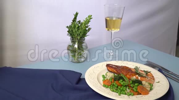 在一张蓝色桌布的桌子上摆着一个盘子上面放着烤猪肉和酱汁和蔬菜装饰着一个白色的视频的预览图