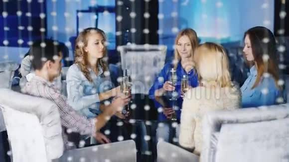 一群年轻朋友在咖啡馆或俱乐部放松坐在桌边喝香槟或酒杯视频的预览图