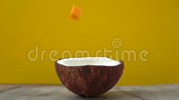 在一个黄色的热带水果被投放到椰奶中后一张摊开椰奶的照片视频的预览图