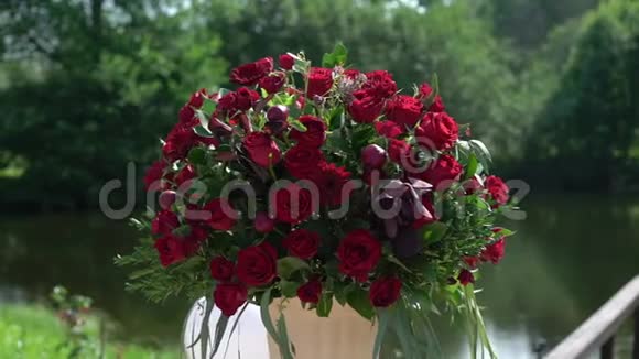 夏日阳光明媚的乡村举行的婚礼上红玫瑰鲜花组合花束视频的预览图
