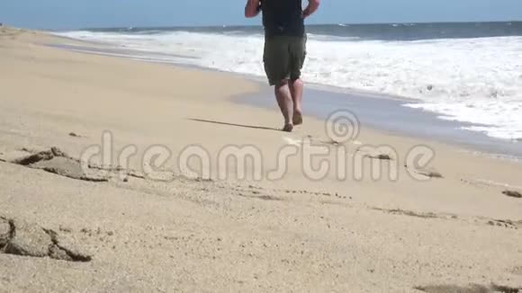 赤脚的年轻人在海滩上奔跑视频的预览图