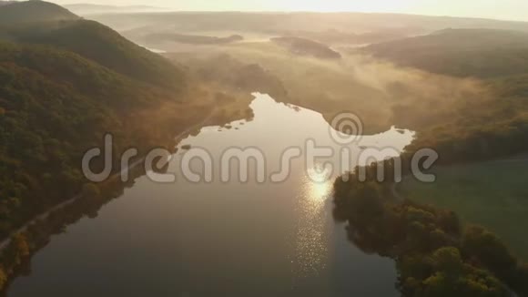 鸟瞰湖和温暖的日落或日出与雾视频的预览图