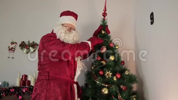 圣诞老人正在装饰一棵圣诞树视频的预览图