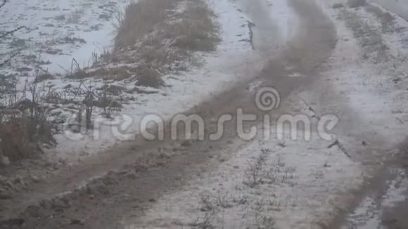 潮湿的冬雪和晨雾中恶劣的农村农田道路视频的预览图