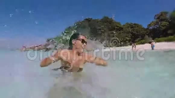 水溅与可爱的白种人女孩在清澈的海水中战斗高清GoPro慢动作镜头泰国视频的预览图