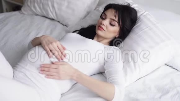 躺在床上爱抚婴儿的孕妇视频的预览图