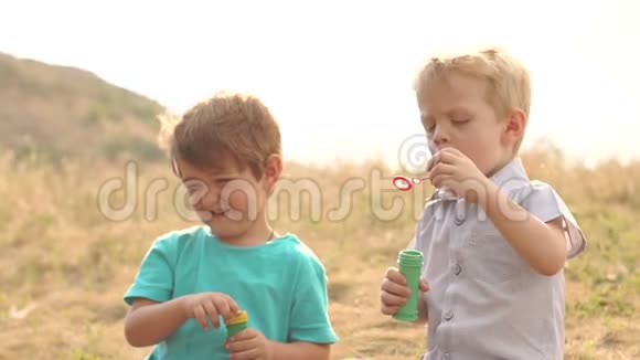 在公园日落时男孩们玩肥皂泡视频的预览图