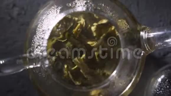 的过程在一个玻璃透明茶壶里冲泡凉茶举行家茶仪式视频的预览图