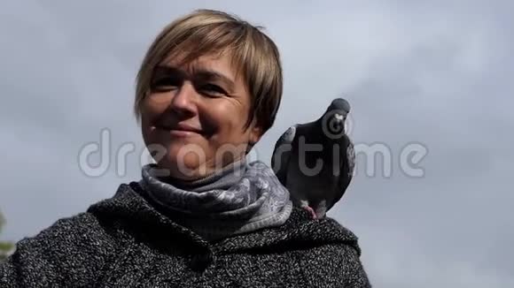 微笑的女人把鸽子放在她的手上放在懒懒中视频的预览图