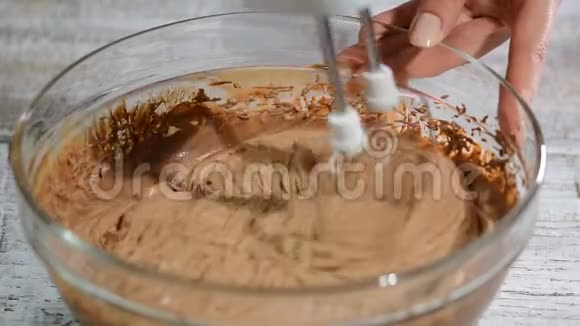糖果师用手搅拌机敲打巧克力奶油在厨房做巧克力奶油视频的预览图