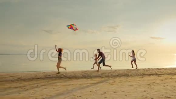 妈妈玩儿童风筝孩子们在海滩上玩得开心无忧无虑视频的预览图