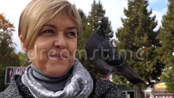 一个幸福的女人站着肩膀上有一只鸽子在邋遢视频的预览图