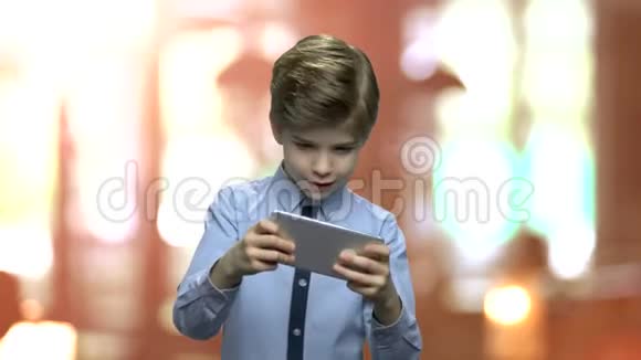 可爱的小男孩在电话里玩游戏视频的预览图