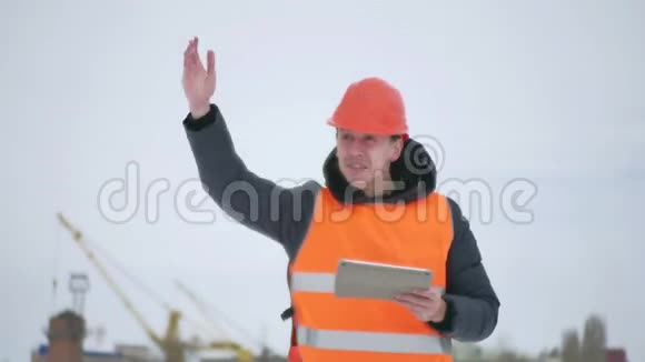 建筑工头挥舞着他的武器建筑师戴着头盔和平板电脑在建筑工地建筑业工人视频的预览图