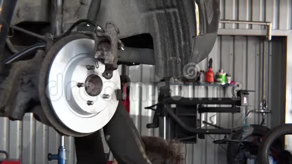 维修车间旧车上安装新制动盘的工人特写视频的预览图