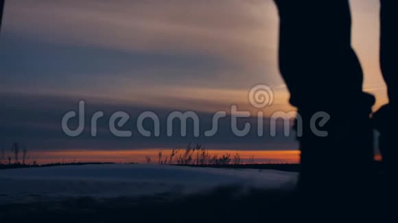 人冬季背景模糊剪影雪照一群游客走在夕阳的剪影山上视频的预览图