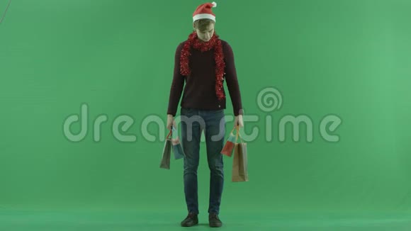 圣诞前夜带着购物袋的男人绿色的彩色钥匙背景视频的预览图