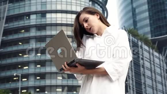 忙碌的女商人在手提电脑和电话上工作视频的预览图