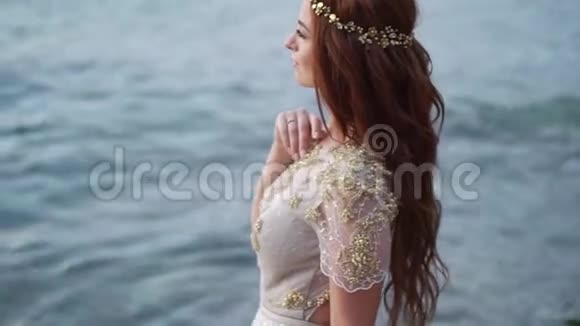 傍晚或日落时在海边的年轻新娘在海洋附近浪漫视频的预览图