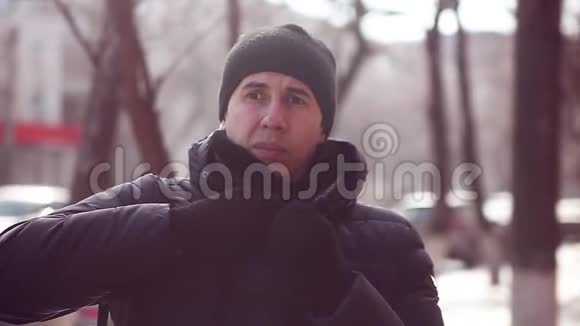 穿着冬衣戴着冬帽的人站在室外寒冷的城市里视频的预览图