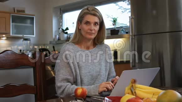 在家工作的女人吃了一口苹果视频的预览图