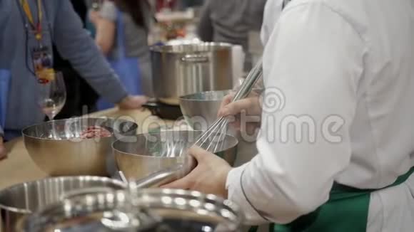 厨师的双手用一把大金属刀切开新鲜的卷心菜头放在一个方形的木板上把锅子盖上视频的预览图