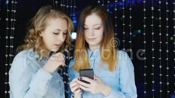 两个年轻女性朋友在夜总会用你的智能手机视频的预览图