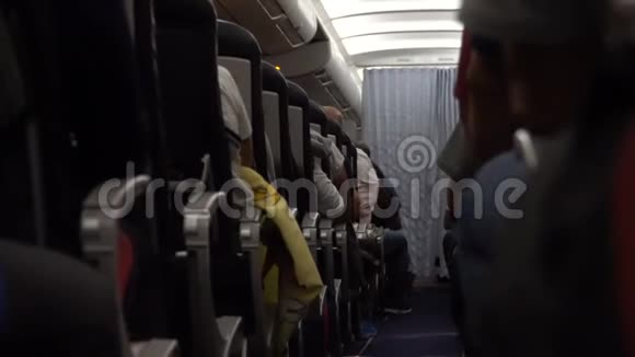飞机内部乘客在飞行过程中在座位上过道上的椅子视频的预览图
