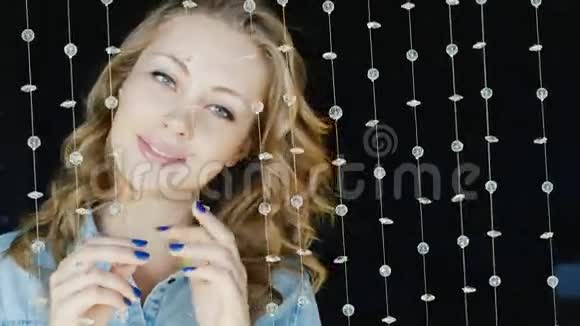 一个迷人的年轻女人看镜头的肖像在夜总会装饰玻璃珠子的费用视频的预览图