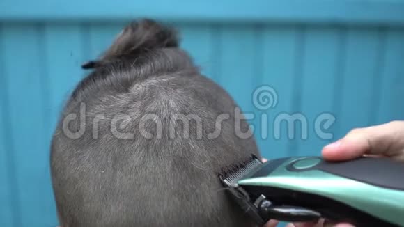 理发师用电动剃须刀和梳子在客户的头发上剪头发视频的预览图