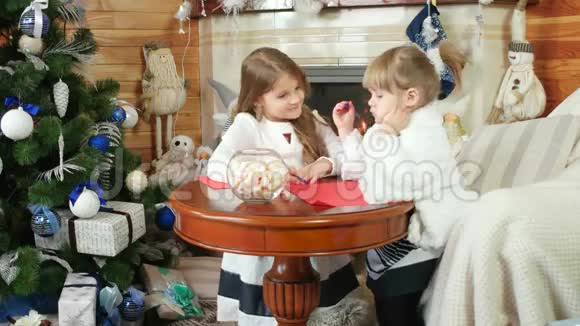 给圣诞老人的信两个女孩姐姐写信画画女孩坐在壁炉附近孩子在房子附近视频的预览图