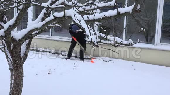 冬天人们用铲子沿着墙壁清扫雪地小道4公里视频的预览图