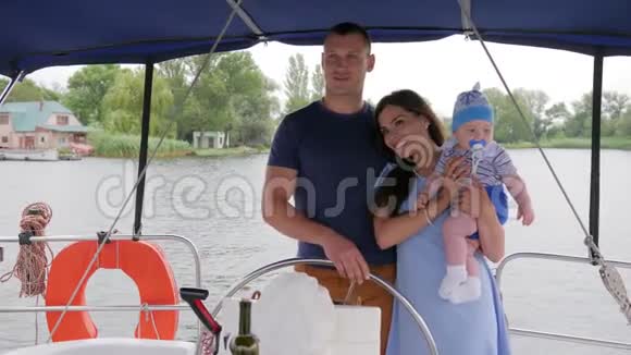 妈妈爸爸和小孩暑假在河上配偶和妻子带小孩在游艇上家庭旅行视频的预览图