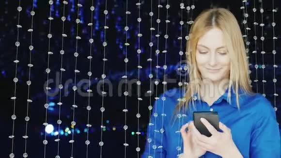 一个迷人的年轻女子在夜总会里享受智能手机视频的预览图