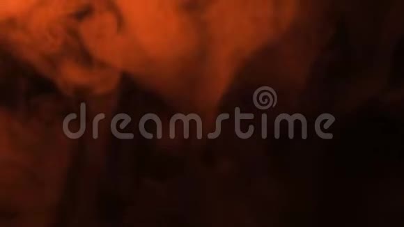 在黑色背景上喷出的橙色烟雾被火照亮视频的预览图