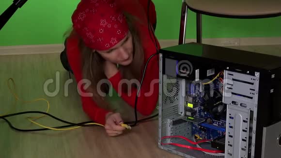 年轻女子试图修理桌子底下的电脑视频的预览图