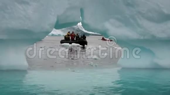南极洲浮冰和冰山附近的橡皮艇上的人视频的预览图