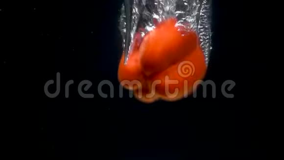 黑色背景下水中落红甜椒的足迹视频的预览图