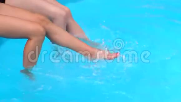 泳池里两个女孩修长的腿特写视频的预览图