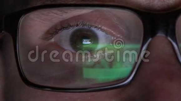 戴眼镜的特写男人的眼睛在晚上的笔记本电脑上工作视频的预览图