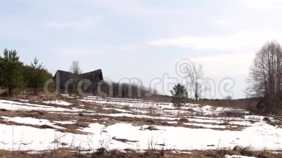被遗弃和摧毁的俄罗斯村庄小屋分别矗立在雪地里春天的时候视频的预览图