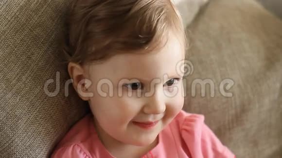 一个小女孩吃糖果微笑着看着相机视频的预览图