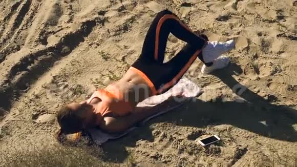 金发美女在沙滩上做腹肌练习视频的预览图