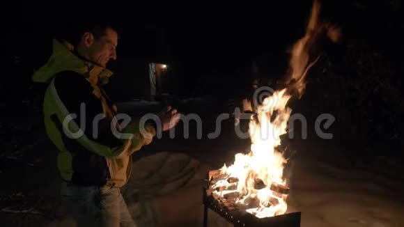 一个人在布拉齐尔附近用火取暖在冬天他的手取暖视频的预览图
