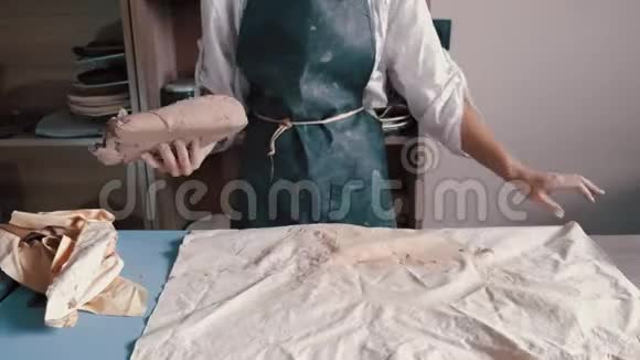 一个穿围裙的女陶工准备和滚泥视频的预览图
