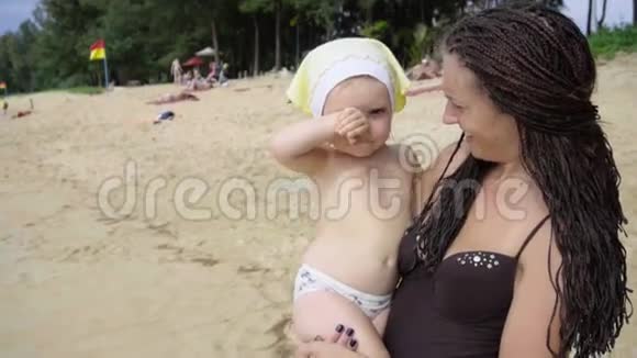 小悲伤的女孩在海滩上拥抱她的母亲视频的预览图