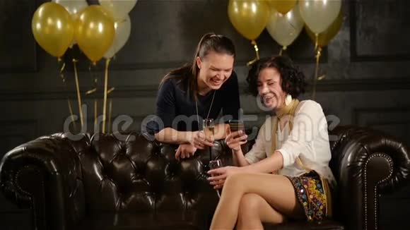 派对期间两个不伦的小礼服特写和手中拿着香槟的眼镜女士们正在使用视频的预览图