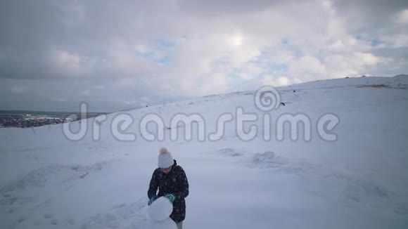 妇女和儿童一起在山上雕刻一个雪人视频的预览图