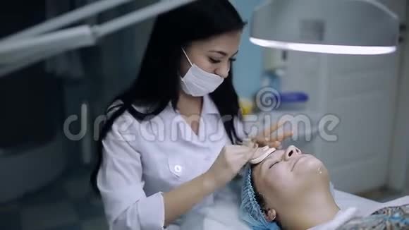 美容师给一个皮肤有问题的年轻女孩洗脸痤疮面部按摩视频的预览图