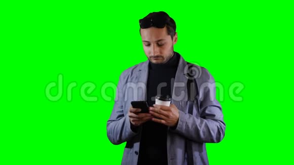 穿西装的人用手机拿着咖啡杯绿色屏幕录像视频的预览图